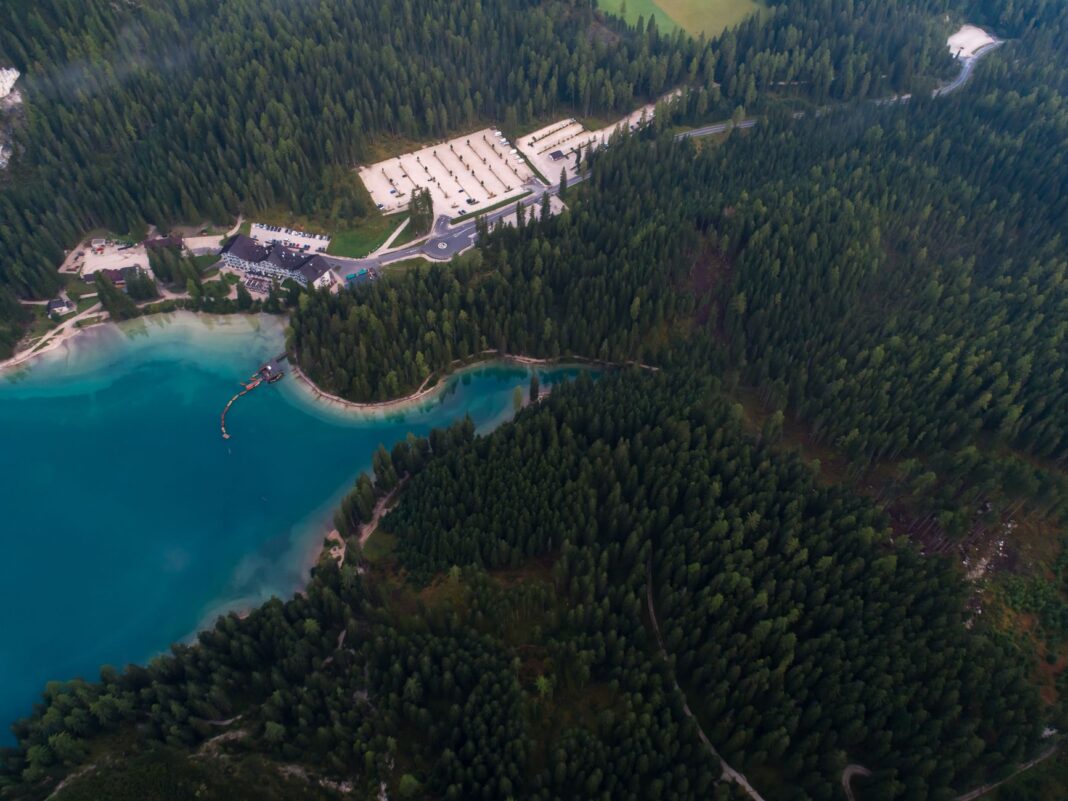 Resort nad turkusowym jeziorem otoczony lasem, ujęcie z drona Resort nad turkusowym jeziorem otoczony lasem, ujęcie z drona