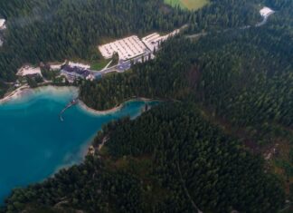 Weekend w Mikołajkach: jaki nocleg wybrać, by nie tracić czasu na dojazdy Resort nad turkusowym jeziorem otoczony lasem, ujęcie z drona